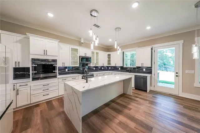 a large white kitchen with stainless steel appliances