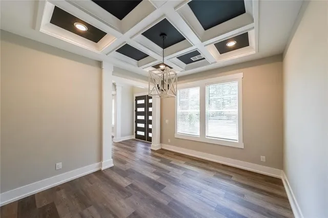 an empty room with wooden floor ceiling fan and windows