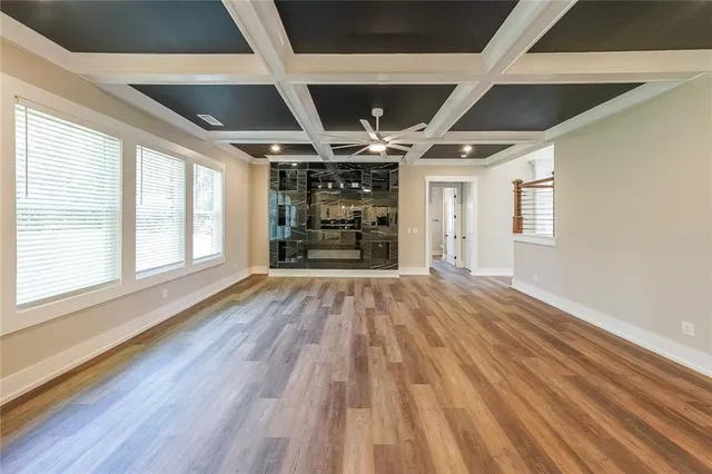 a view of empty room with wooden floor and windows