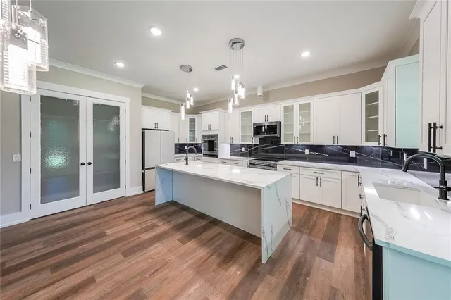 a kitchen with stainless steel appliances kitchen island granite countertop a sink and cabinets