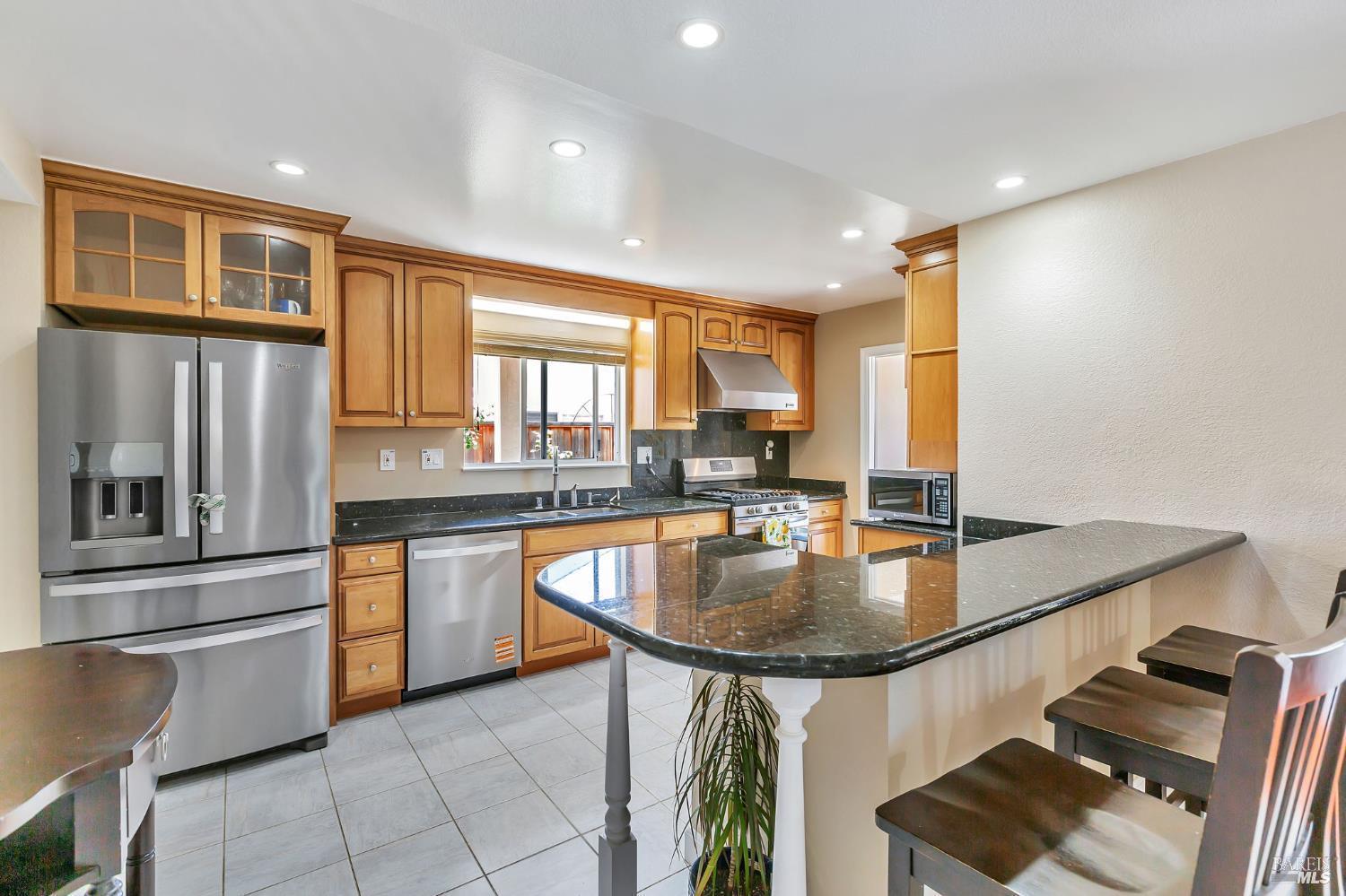 99 San Benito Way Novato, CA 94945 - Photo 4 of 30 a kitchen with stainless steel appliances granite countertop a sink a stove and a refrigerator