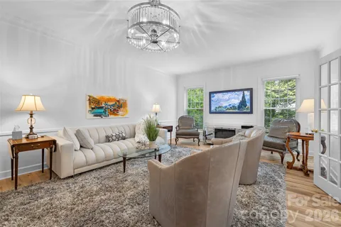 a living room with furniture a chandelier and a flat screen tv