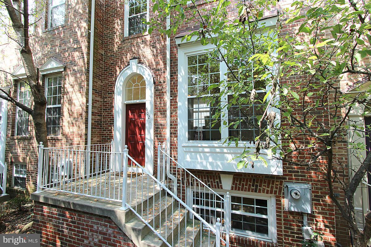 6021 Riddle Walk Alexandria, VA 22312 - Photo 1 of 30 a view of a brick house with large windows and a tree