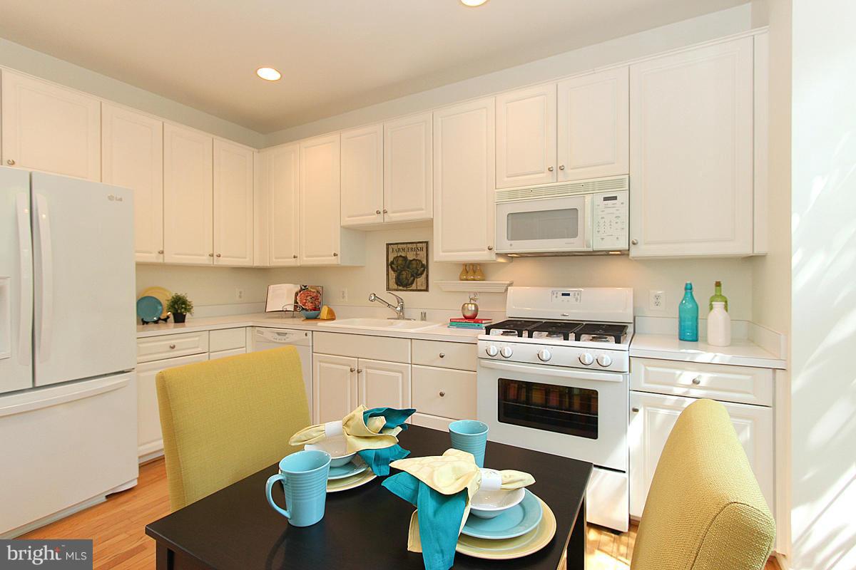 6021 Riddle Walk Alexandria, VA 22312 - Photo 5 of 30 a kitchen with a white stove top oven and white cabinets