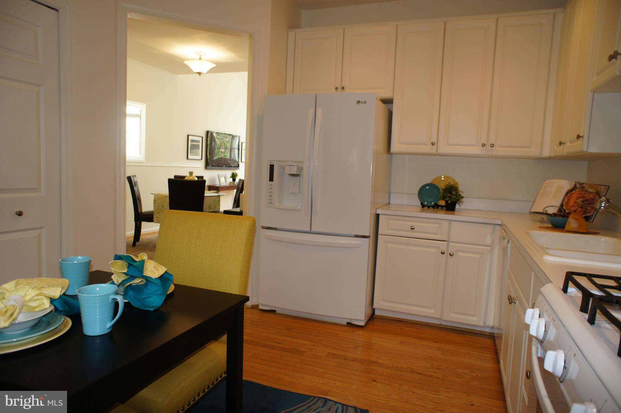 6021 Riddle Walk Alexandria, VA 22312 - Photo 7 of 30 a kitchen with stainless steel appliances refrigerator cabinets and wooden floor