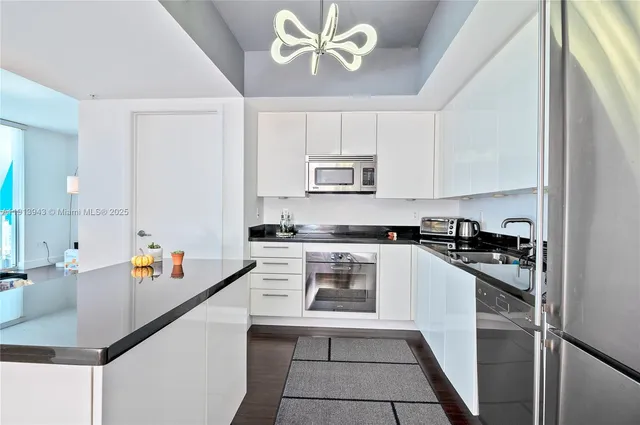 a kitchen with stainless steel appliances granite countertop a sink stove refrigerator and cabinets