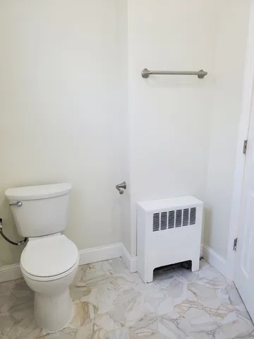a bathroom with a toilet and a mirror