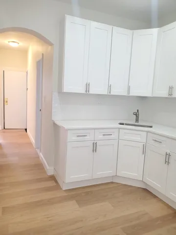 a view of a kitchen with white cabinets