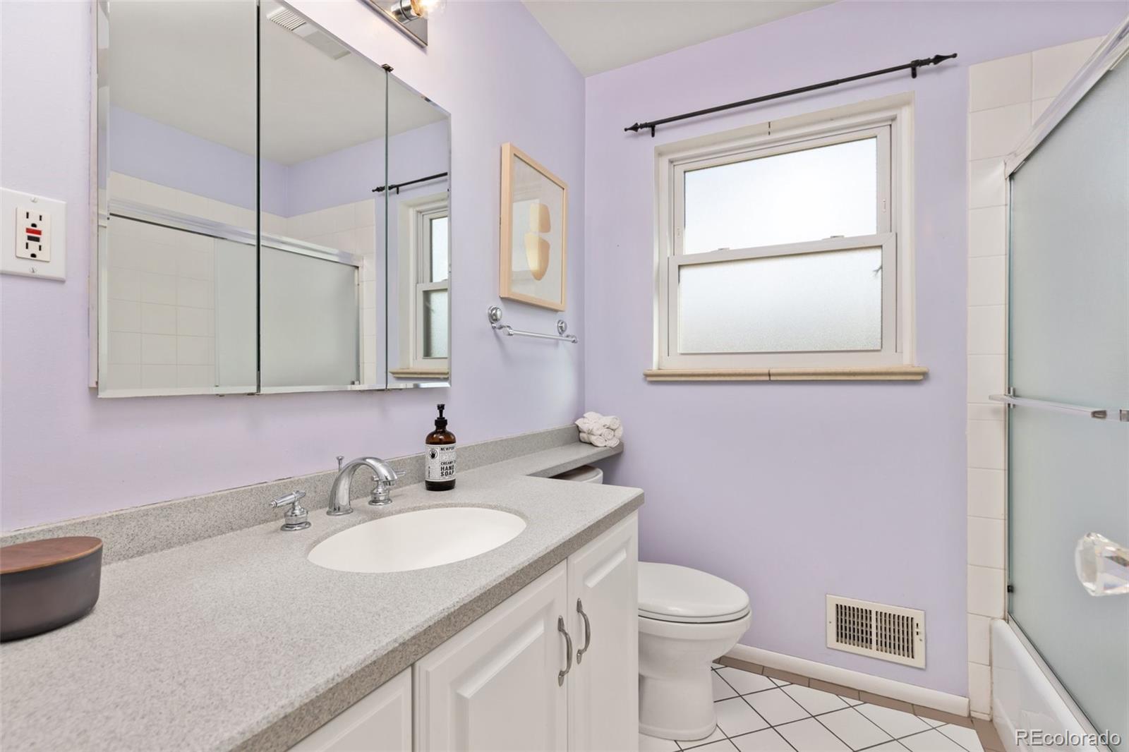 5520 East Bails Drive Denver, CO 80222 - Photo 17 of 38 a bathroom with a granite countertop sink toilet and a mirror