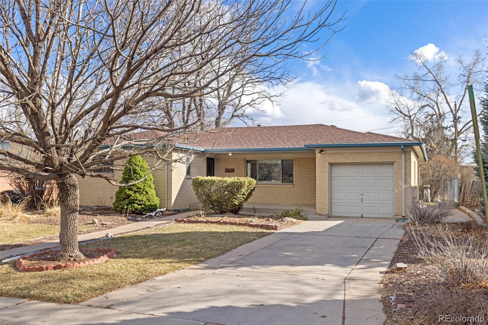 5520 East Bails Drive Denver, CO 80222 - Photo 29 of 38 a front view of a house with a yard and garage