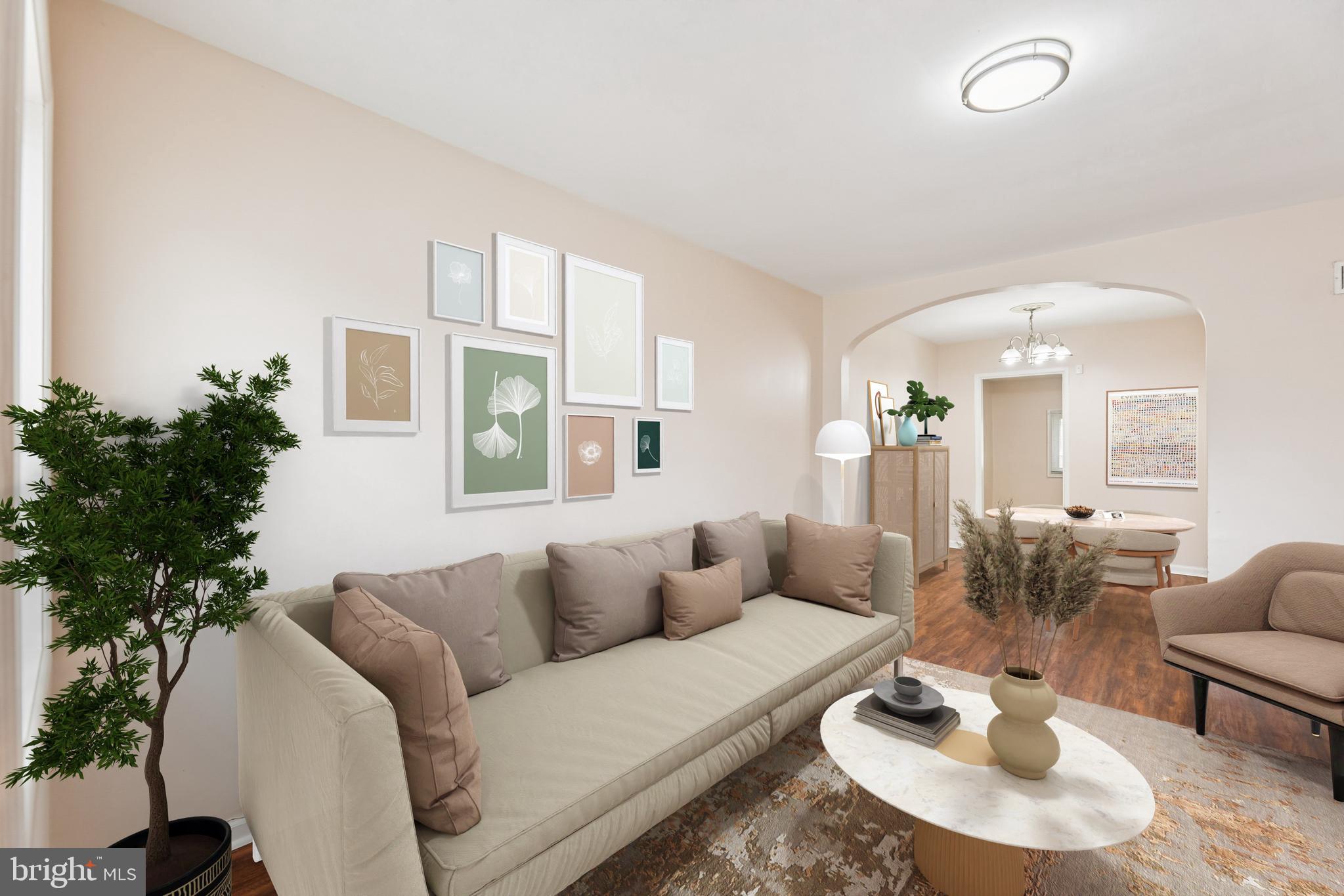 a living room with furniture potted plant and a large window