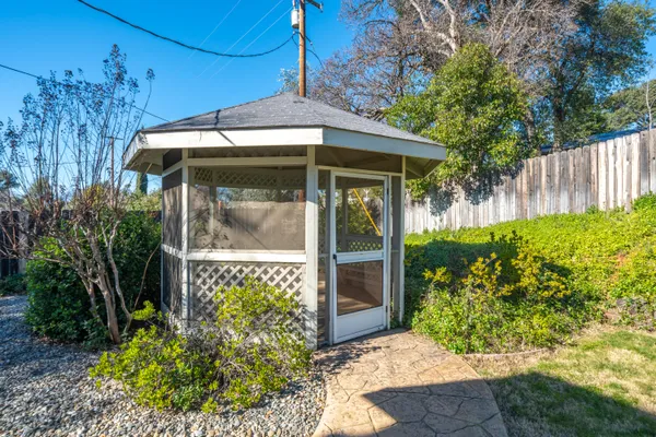 a view of a swimming pool with a fountain and trees in the background
