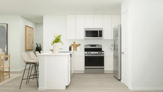 a kitchen with stainless steel appliances a stove a microwave and a refrigerator