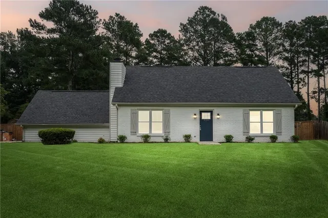 a front view of a house with a yard and trees