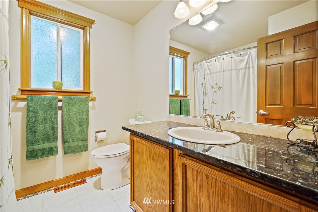 2111 237th Street Southeast Bothell, WA 98021 - Photo 22 of 30 a bathroom with a granite countertop sink a toilet and a mirror