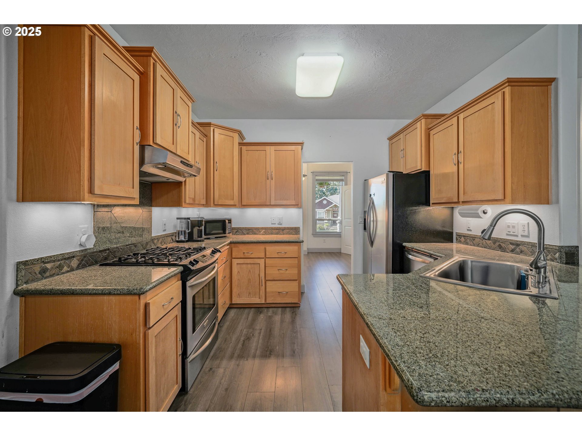 466 Northwest Denton Avenue Dallas, OR 97338 - Photo 10 of 43 a kitchen with kitchen island granite countertop a sink stove and refrigerator