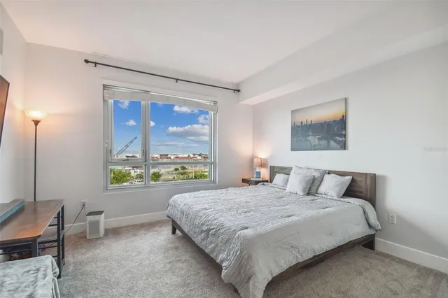 a bedroom with a large bed and a lamp next to a window