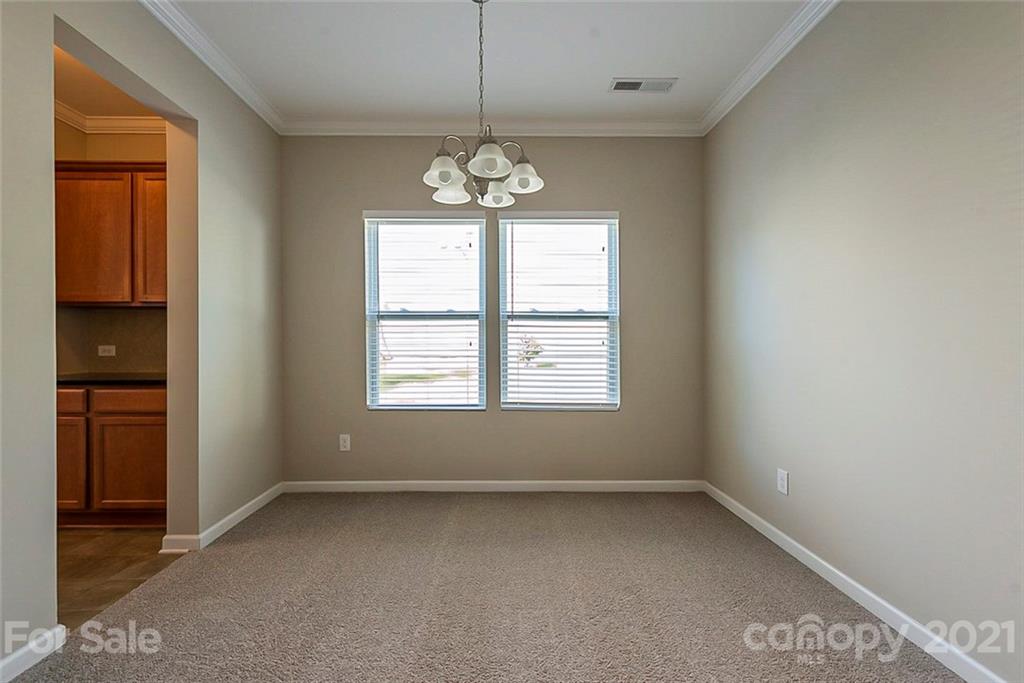9019 Klein Road Fort Mill, SC 29715 - Photo 11 of 19 an empty room with chandelier and windows