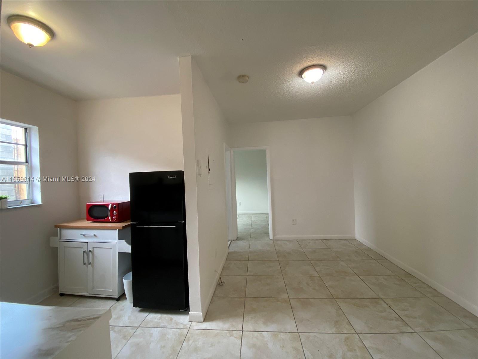 1043 Northwest 2nd Street, Unit 16 Miami, FL 33128 - Photo 11 of 17 a kitchen with a refrigerator and a sink