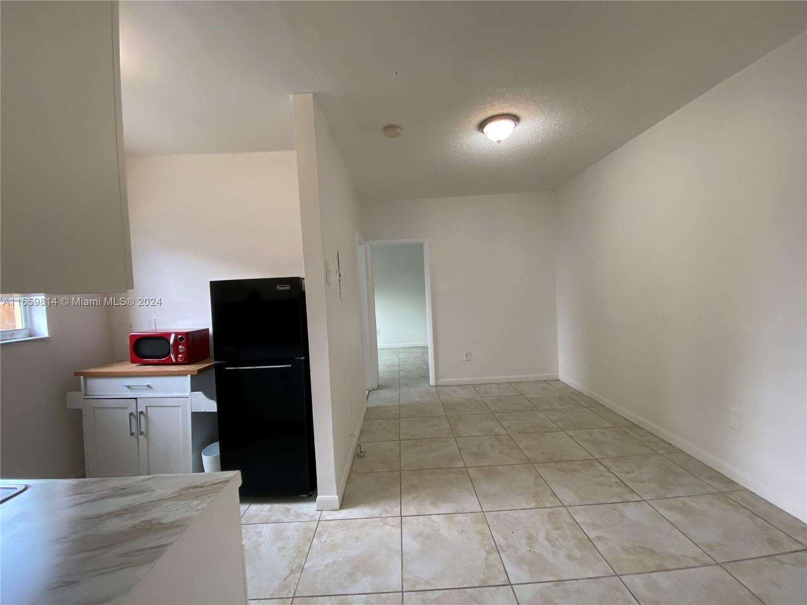 1043 Northwest 2nd Street, Unit 16 Miami, FL 33128 - Photo 2 of 17 a kitchen with a refrigerator and a stove top oven