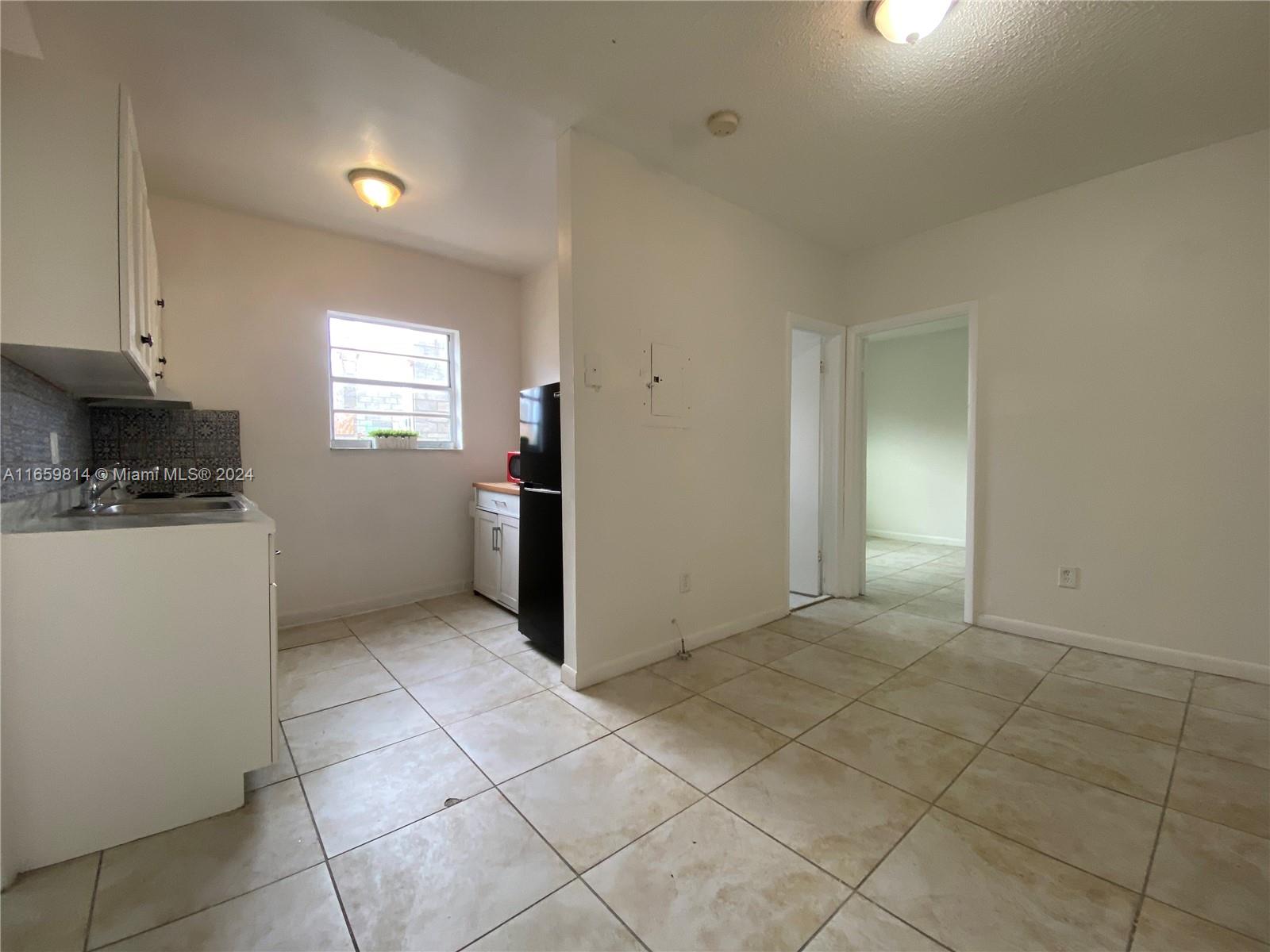 1043 Northwest 2nd Street, Unit 16 Miami, FL 33128 - Photo 5 of 17 a view of a kitchen with a sink cabinets and window