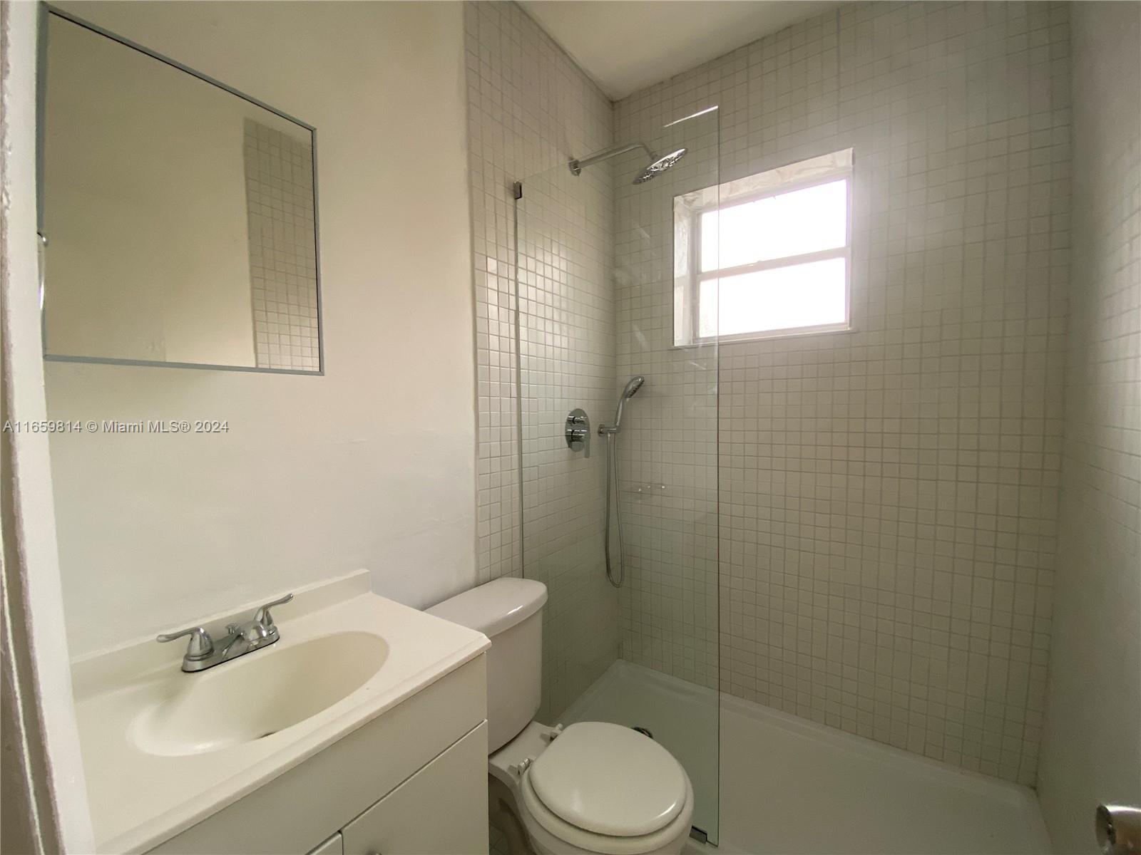 1043 Northwest 2nd Street, Unit 16 Miami, FL 33128 - Photo 6 of 17 a bathroom with a sink toilet and shower