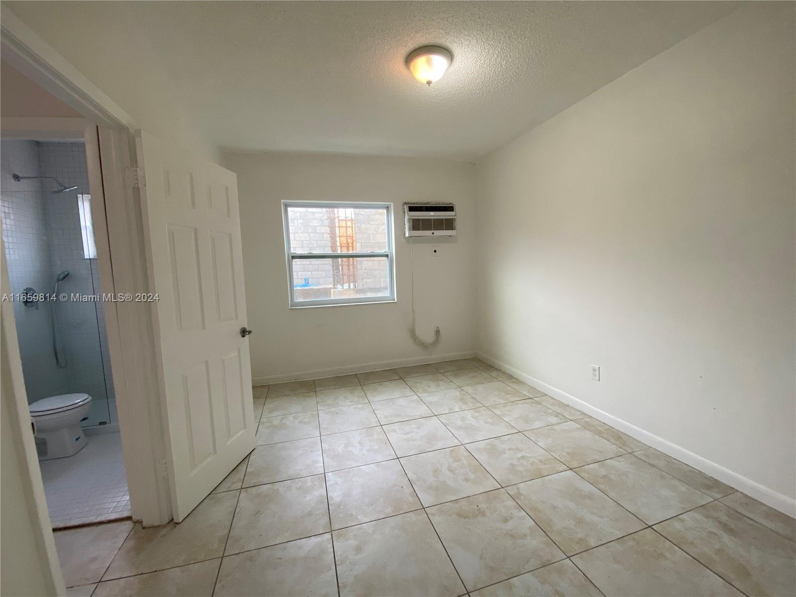 1043 Northwest 2nd Street, Unit 16 Miami, FL 33128 - Photo 7 of 17 a view of an empty room with a window