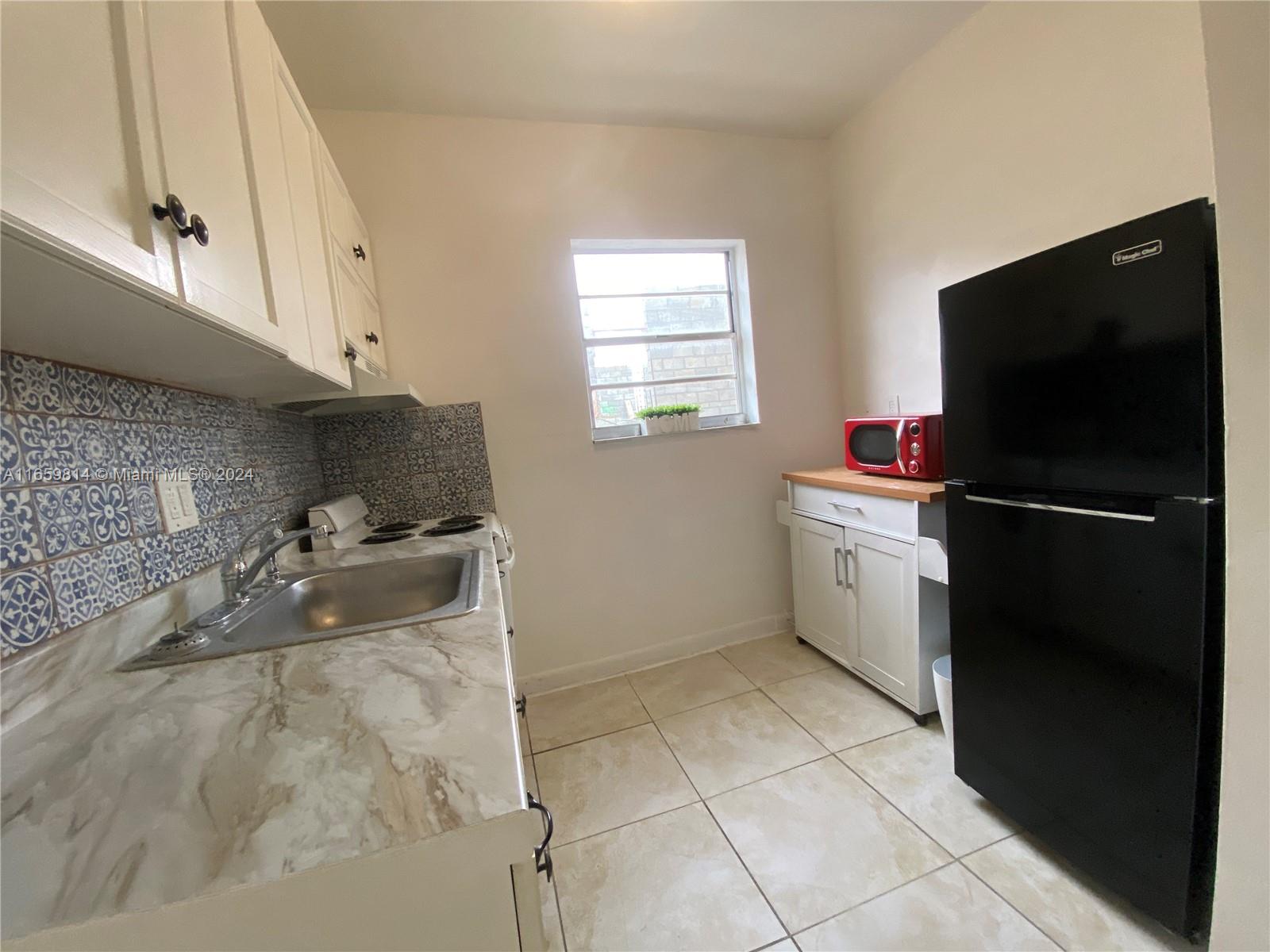 1043 Northwest 2nd Street, Unit 16 Miami, FL 33128 - Photo 9 of 17 a kitchen with a refrigerator and a sink