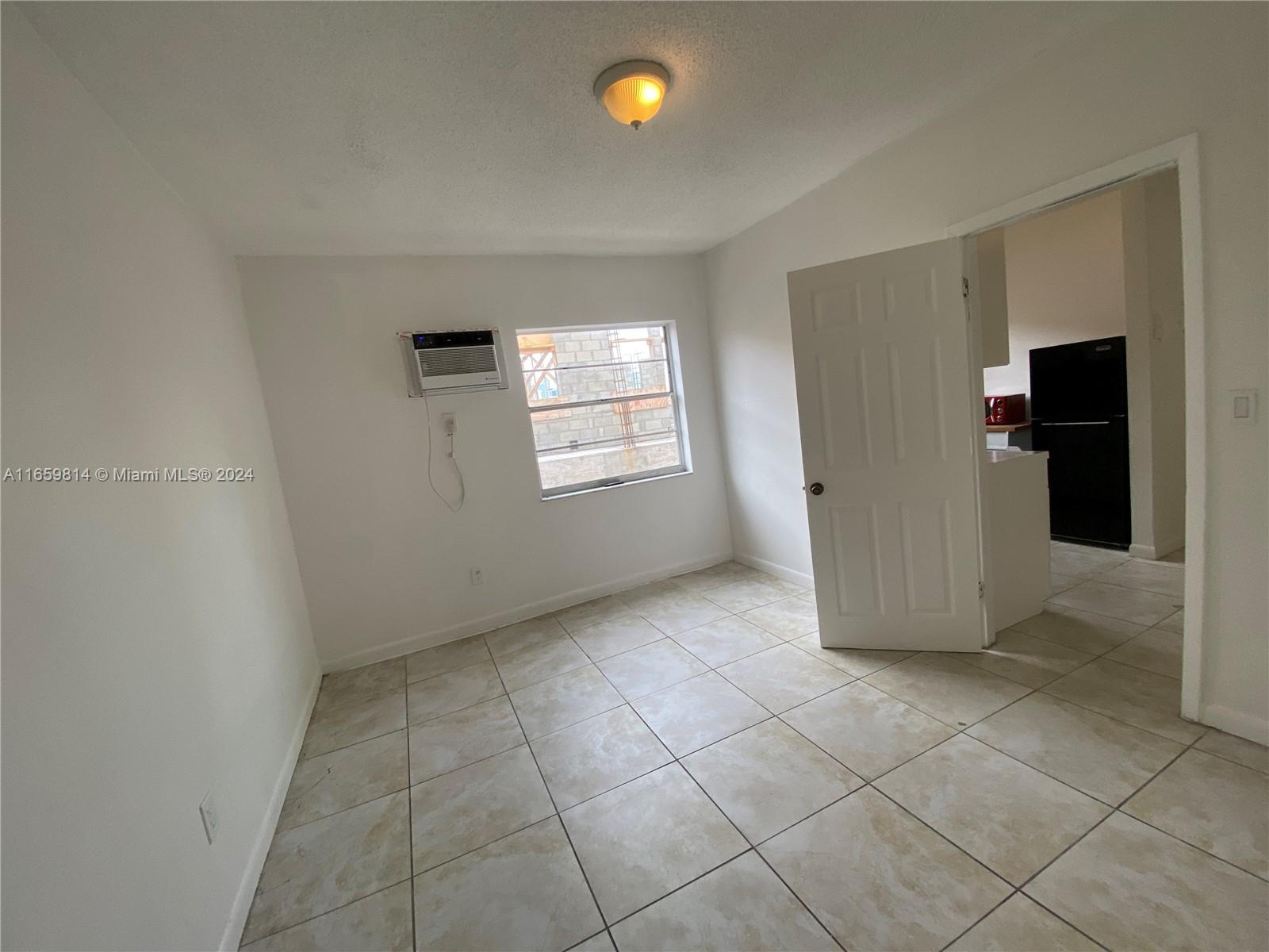 1043 Northwest 2nd Street, Unit 16 Miami, FL 33128 - Photo 10 of 17 an empty room with windows and closet