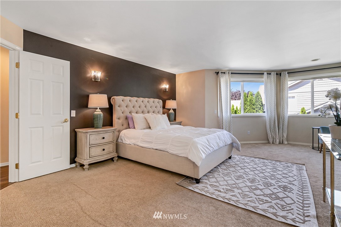 1127 185th Place Southeast Bothell, WA 98012 - Photo 16 of 25 a bedroom with a large bed and windows