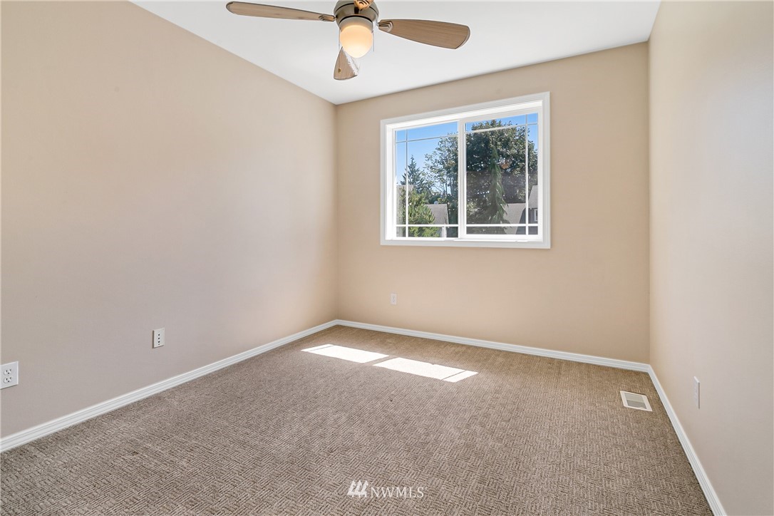 1127 185th Place Southeast Bothell, WA 98012 - Photo 21 of 25 an empty room with a window and a ceiling fan