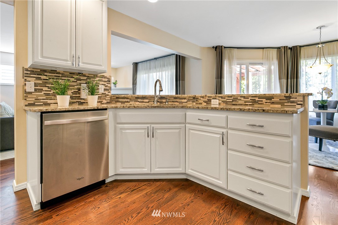 1127 185th Place Southeast Bothell, WA 98012 - Photo 6 of 25 a kitchen with granite countertop white cabinets and sink