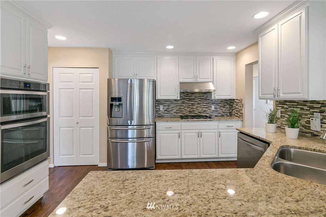 1127 185th Place Southeast Bothell, WA 98012 - Photo 7 of 25 a kitchen with granite countertop a refrigerator and a sink