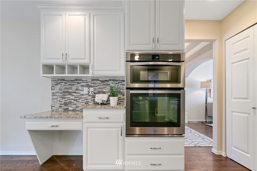 1127 185th Place Southeast Bothell, WA 98012 - Photo 8 of 25 a kitchen with granite countertop a stove and a microwave