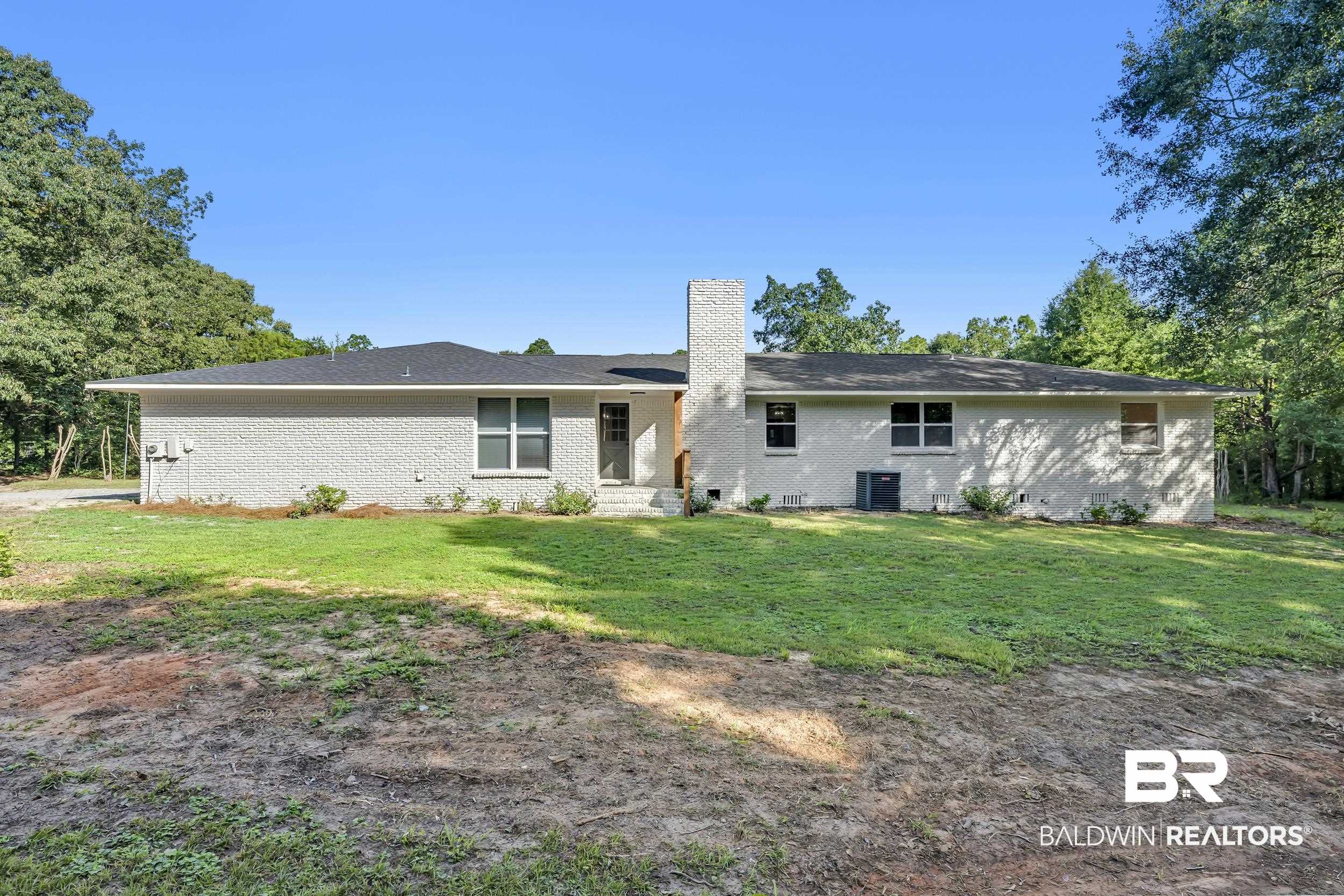 8170 Wilmer Georgetown Road Wilmer, AL 36587 - Photo 24 of 31 White-painted brick exterior with a dark shingle roof and a prominent brick chimney