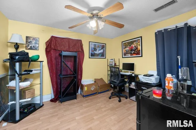 a living room with furniture a desk and chair with a bookshelf