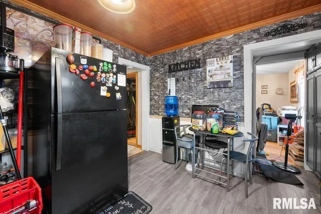 a room with stainless steel appliances a refrigerator and a table