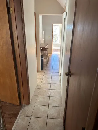 a view of a hallway and a dining room with a mirror