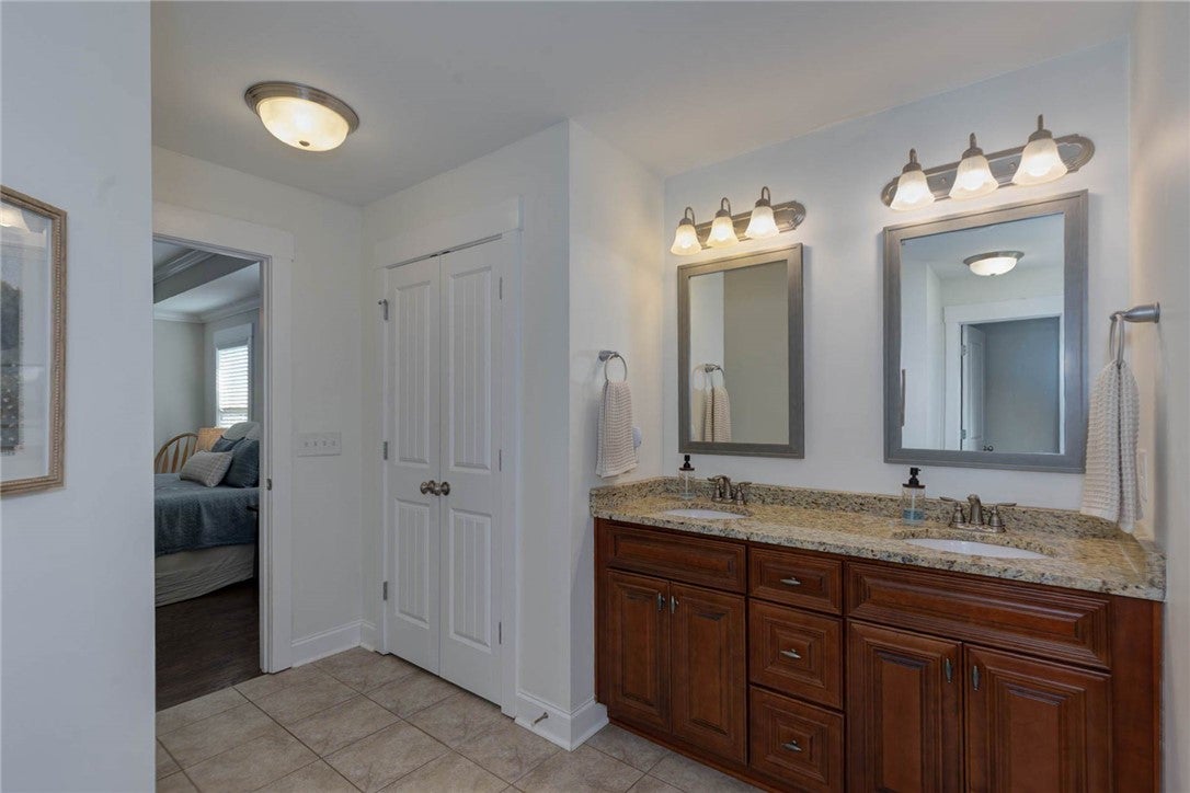 641 Deer Run Road Auburn, AL 36832 - Photo 25 of 28 This bright bathroom features a spacious dual vanity with ample storage and direct access to a cozy bedroom.