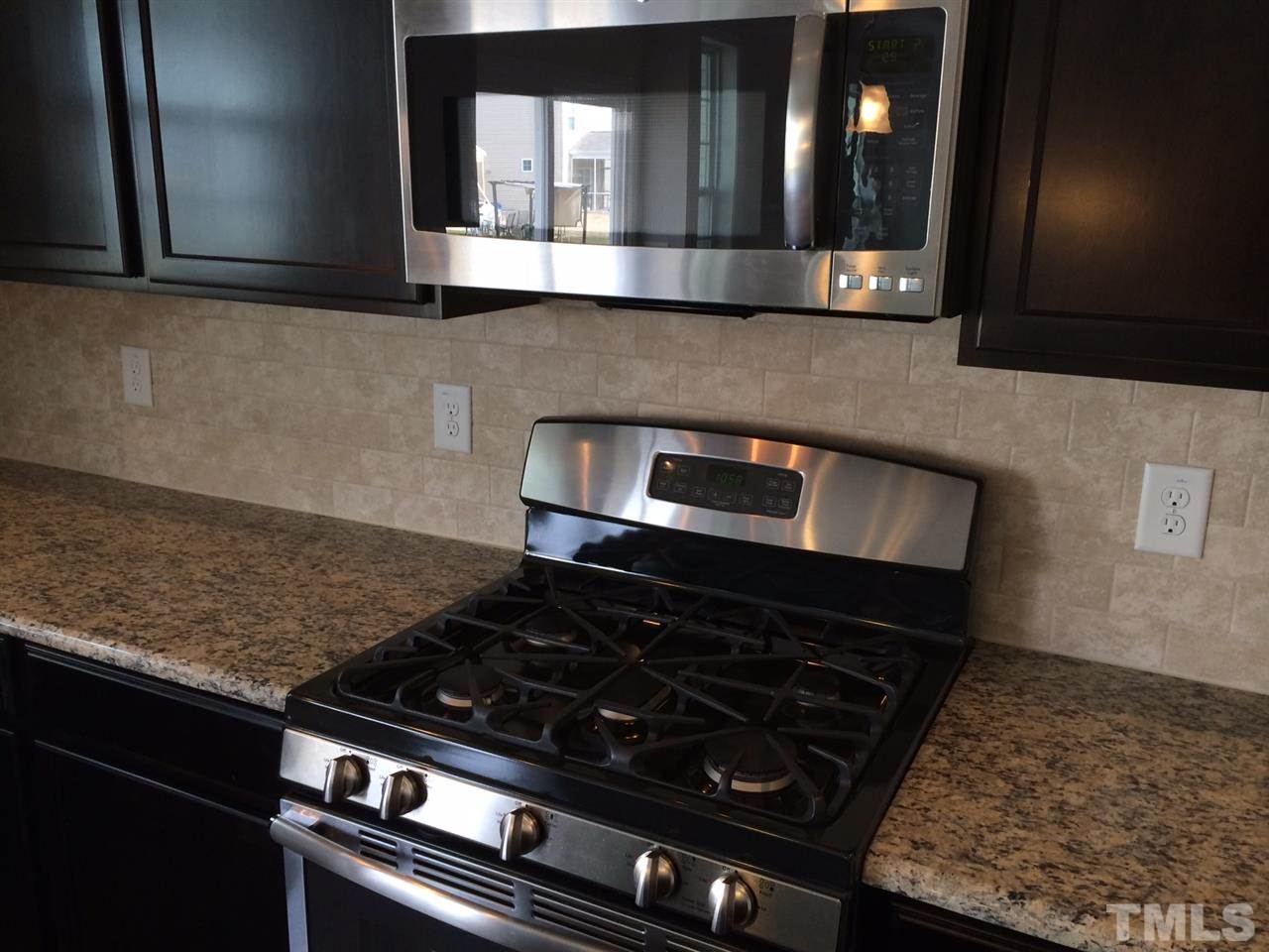 7621 Channery Way Raleigh, NC 27616 - Photo 5 of 25 gas range, the tile backsplash and stainless appliances make this a cooks dream