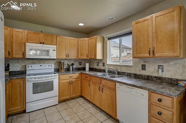 a kitchen with granite countertop white cabinets sink and stainless steel appliances
