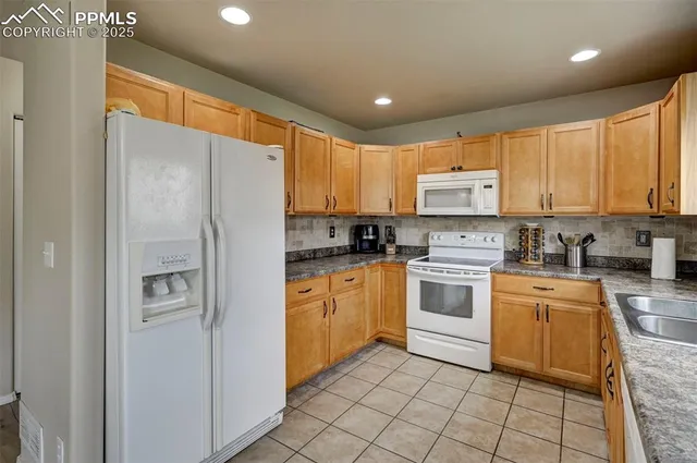 a kitchen with stainless steel appliances granite countertop a refrigerator sink and cabinets