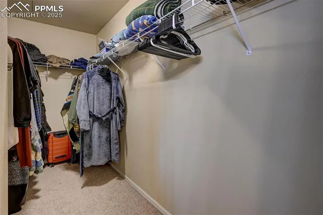 a view of walk in closet with clothes
