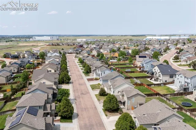 an aerial view of a city with lots of residential buildings and mountain view in back