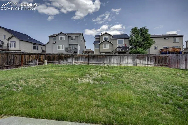 a view of a house with a big yard and a large tree