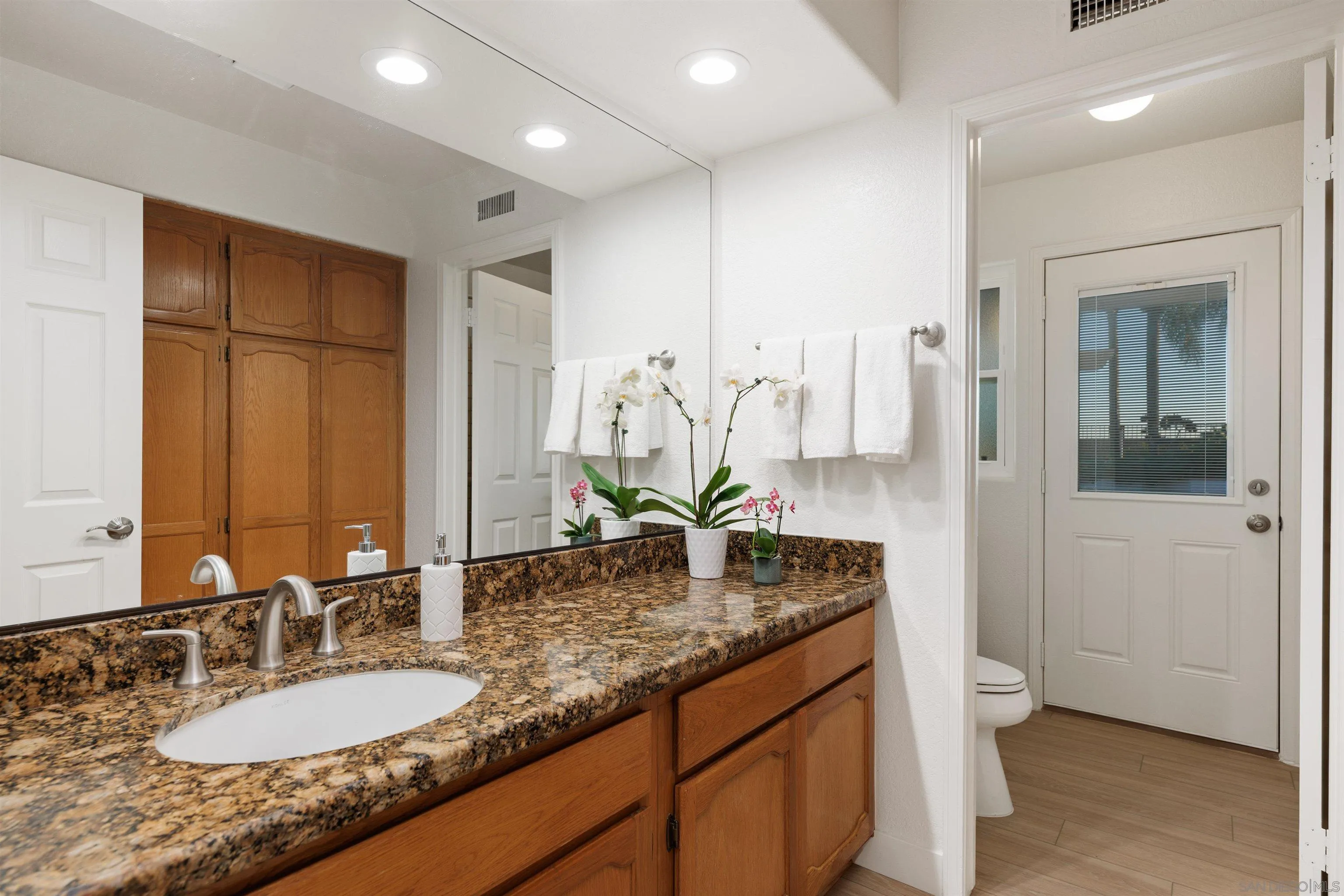 1611 Stoneridge Circle Escondido, CA 92029 - Photo 20 of 30 a bathroom with a granite countertop sink and a mirror