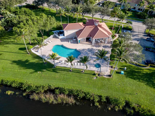 an aerial view of lake residential house with swimming pool and lawn chairs