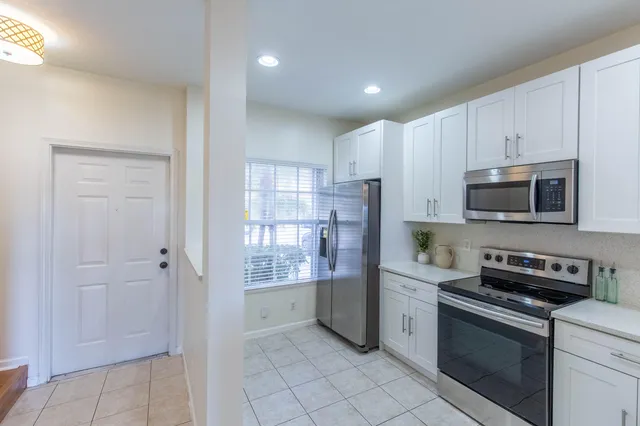 a kitchen with stainless steel appliances granite countertop a refrigerator and a stove top oven