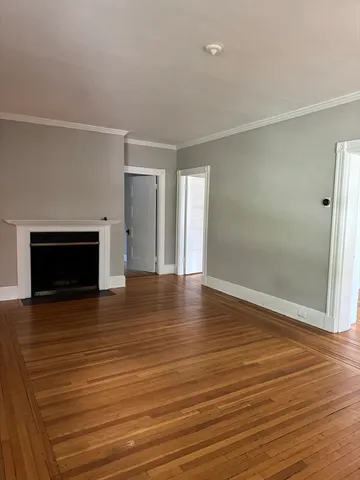 an empty room with wooden floor and fireplace