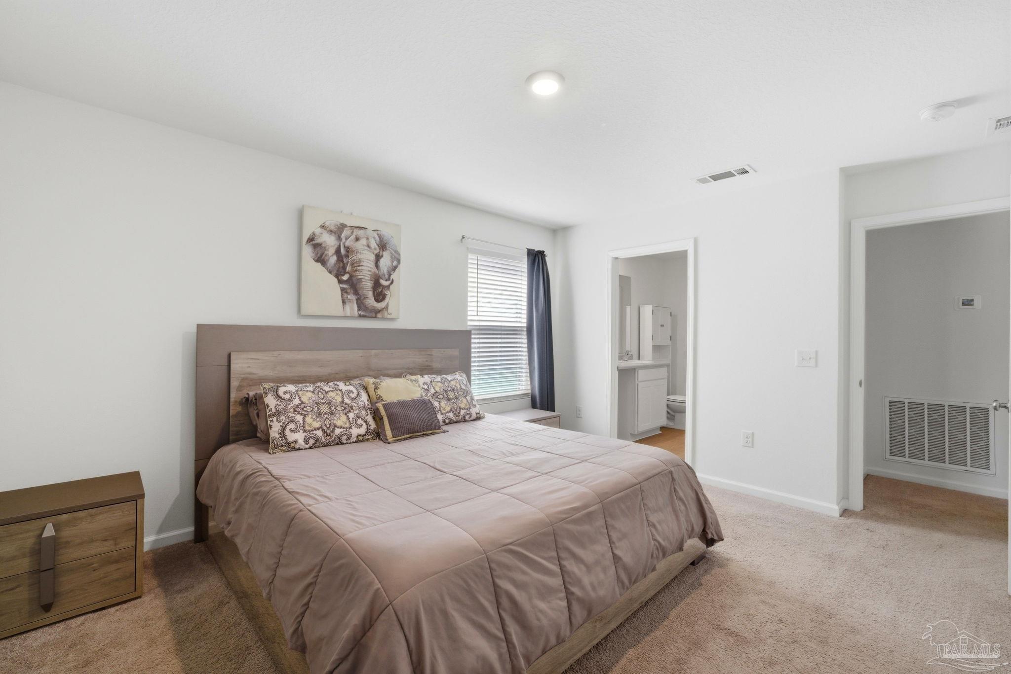 7804 Maxton Road Pensacola, FL 32514 - Photo 10 of 20 a bedroom with a large bed and a chandelier